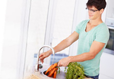 An adult washing vegetables